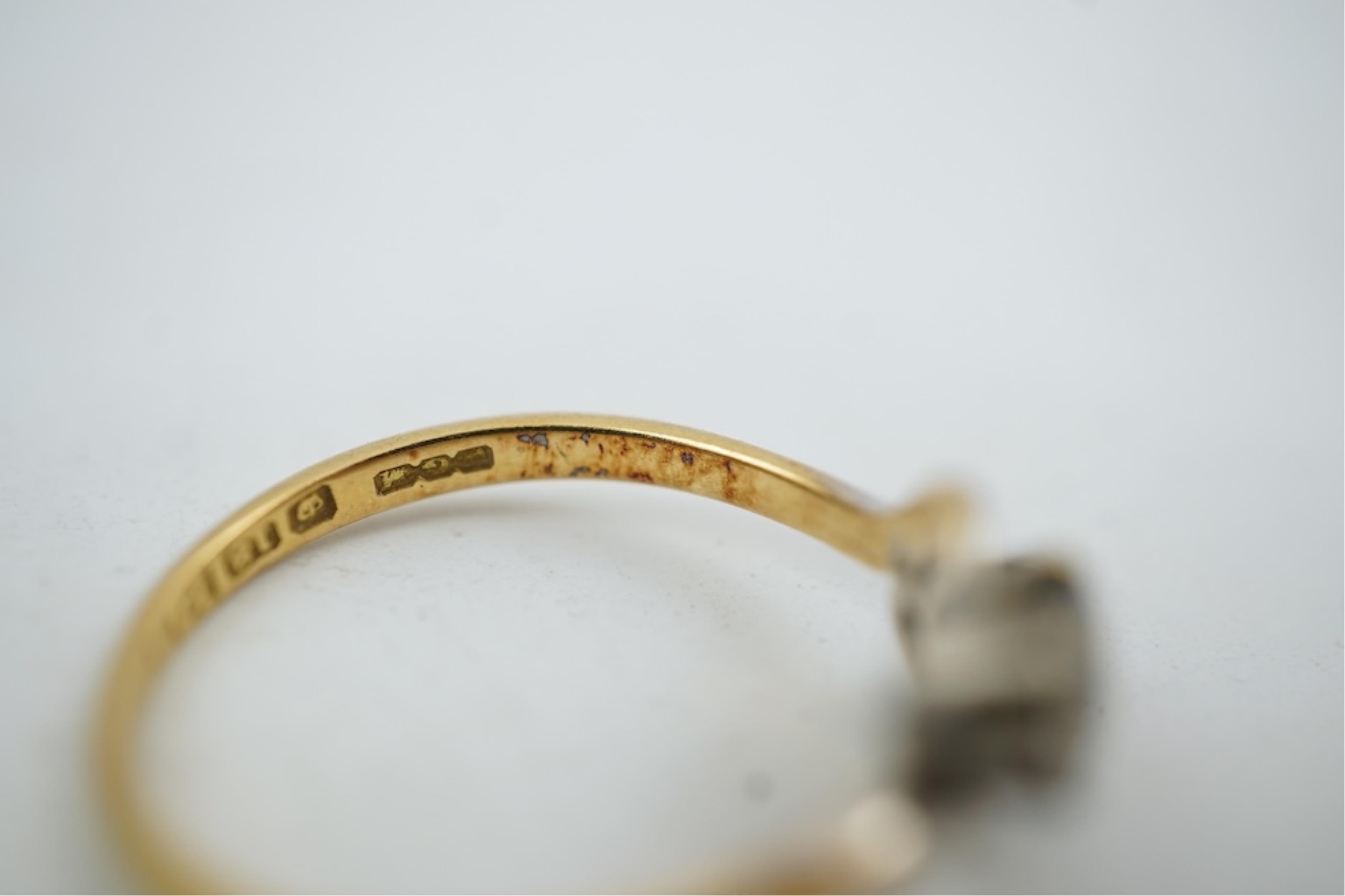 An early 20th century 18ct gold, sapphire and diamond set three stone crossover ring, size P/Q, gross weight 2.4 grams.